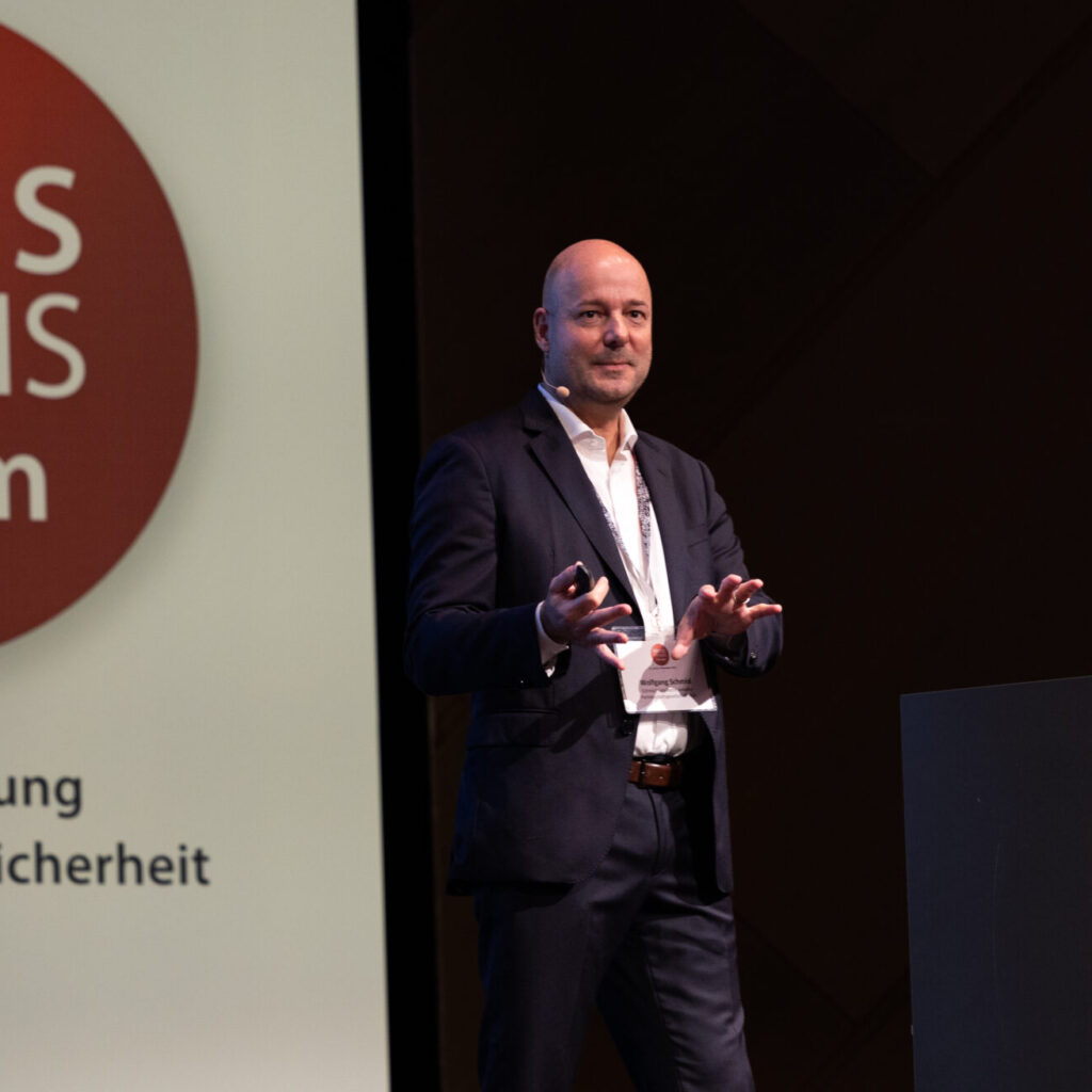 Ein Redner präsentiert auf der KRITIS Praxis Forum Fachkonferenz für ISMS und IT-Sicherheit.